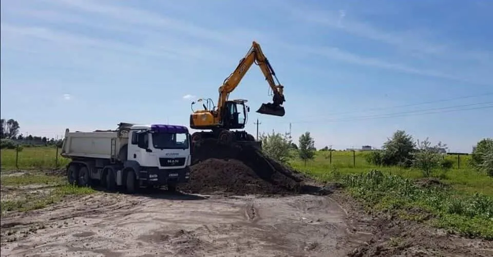 Kotrógép földet rak billenős teherautóra